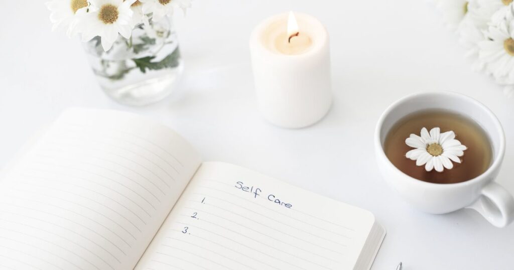 Mein wahres Ich: So findest du zurück zu dir 12 Journalbuch liegt auf dem Tisch mit einer Kerze