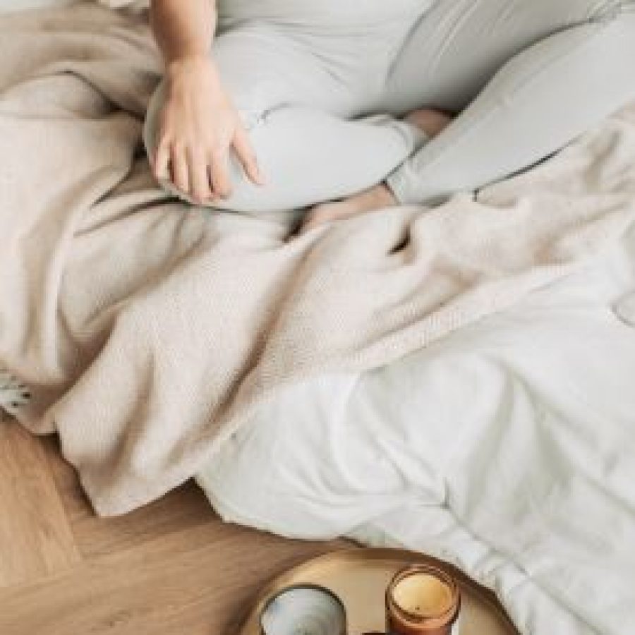 Frau meditiert in einer entspannten Atmosphäre mit Kerzenlicht als Teil eines Coachings für Frauen